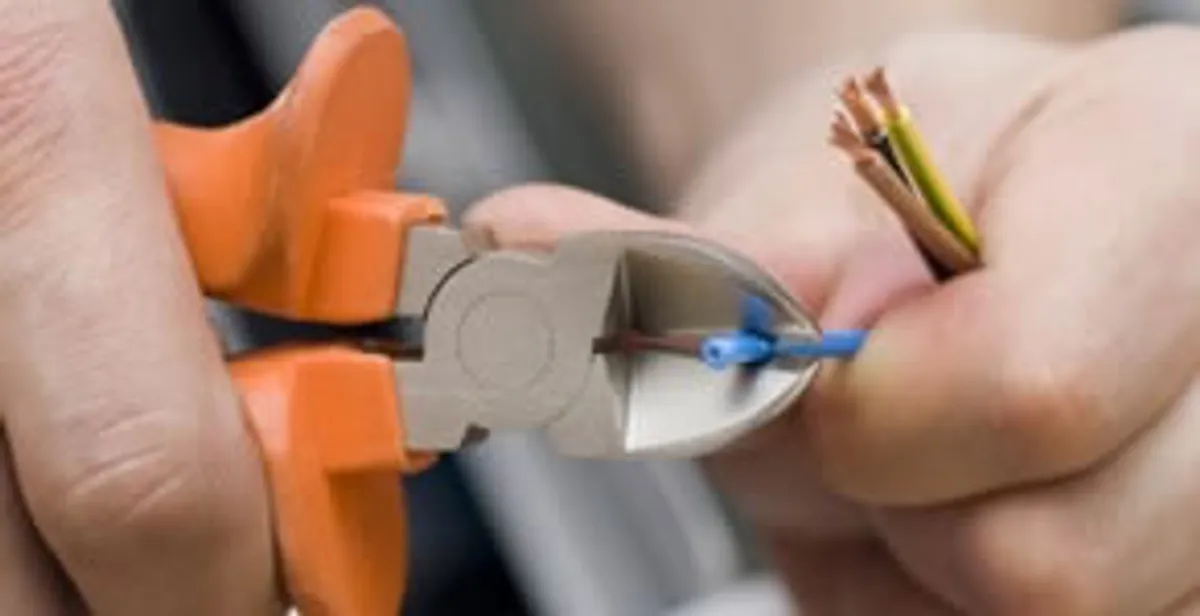 licensed electrician performing precise wire cutting and preparation during electrical service in Flagstaff, AZ